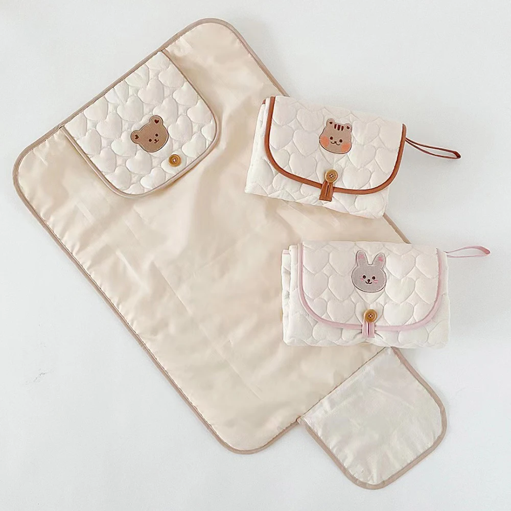 Tapis de change pliable et portable imperméable pour bébé.